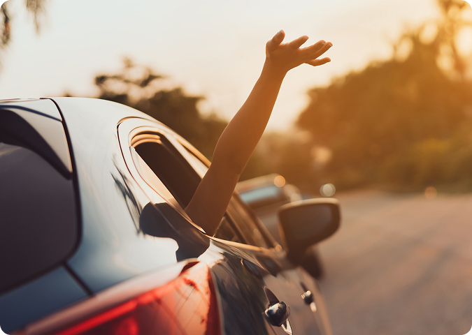 person waving out of the car window