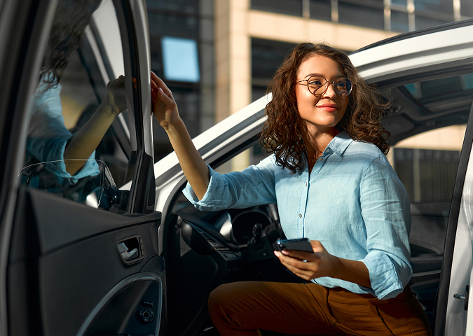 person is sitting on the front seat of a car. with the door half open.